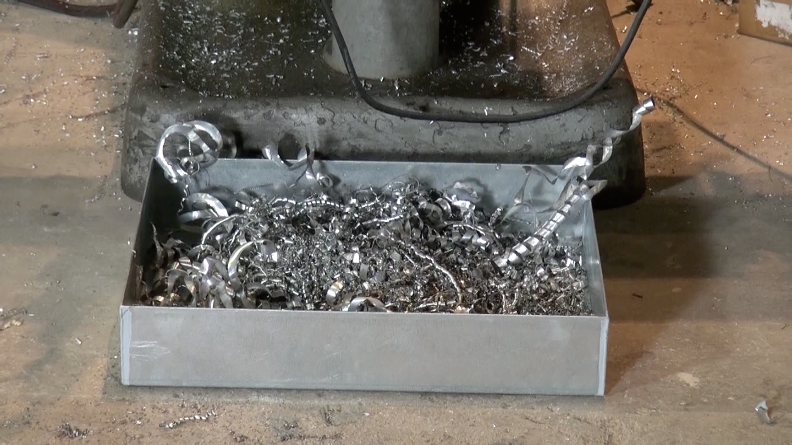 A drip tray is containing part shavings.